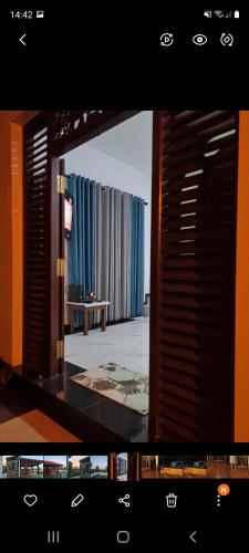 a view of a room with blue curtains and a television at Villa Talpe in Talpe