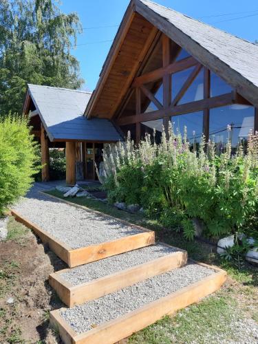 a garden with steps leading to a building at Hostería Las Nieves in Villa La Angostura