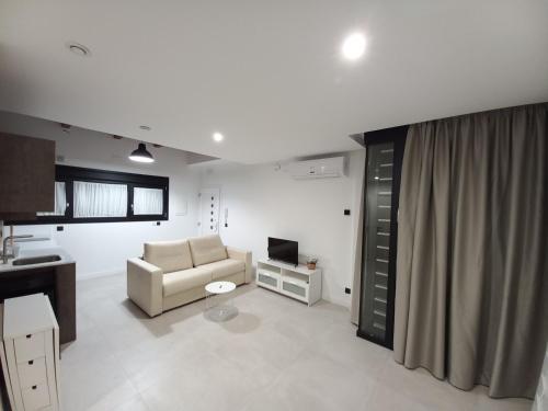 ein Wohnzimmer mit einem Sofa und einem TV in der Unterkunft Apartamentos Las Pasaeras in Montehermoso