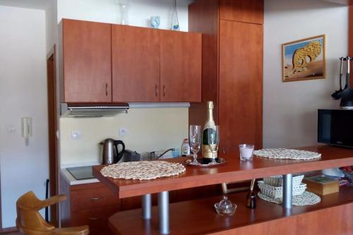 a kitchen with wooden cabinets and a table with a bottle of wine at Mezonetový apartmán v Osčadnici in Oščadnica