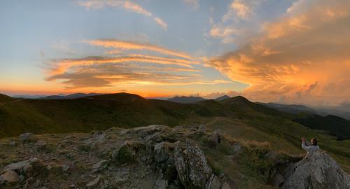 a person standing on top of a mountain at sunset at Nidi del faggio rosso - Family Holiday Home in Maresca