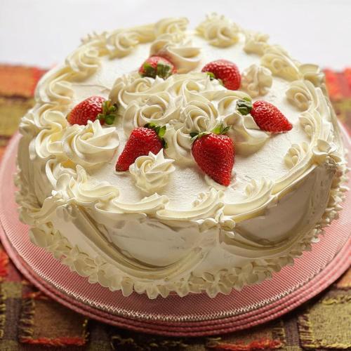 a cake with strawberries on top on a pink plate at Vila Suzana Parque Hotel in Canela