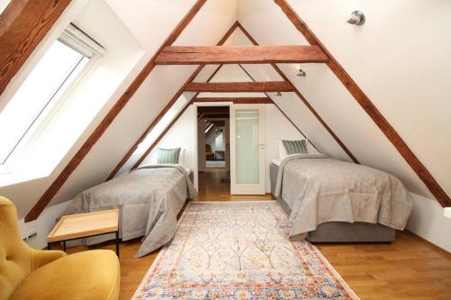 a attic bedroom with two beds and a rug at Tallinn City Apartments 2 bedroom & 2 bathroom luxury property with balcony in Old Town in Tallinn