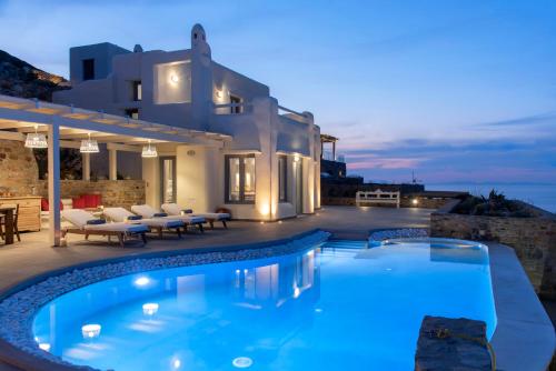 a villa with a swimming pool at night at Naxos Rock Villas in Stelida