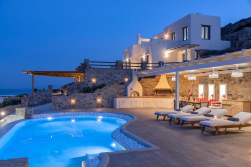 a villa with a swimming pool at night at Naxos Rock Villas in Stelida