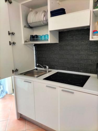 a kitchen with white cabinets and a sink at I 23 PASSI GAETA in Gaeta