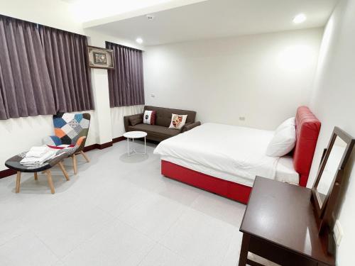 a hotel room with a bed and a couch at 十二籃民宿 in Magong