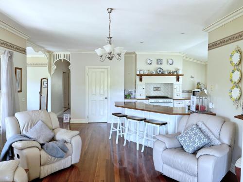 a living room with two chairs and a kitchen at Serenity in Healesville