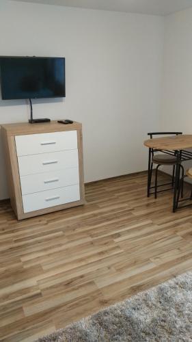 ein Wohnzimmer mit Fernseher und Holzboden in der Unterkunft BiesCZADOWE miejsce in Lesko