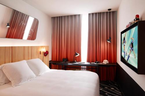 a hotel room with a bed and a flat screen tv at Mama Shelter Paris La Défense in Puteaux