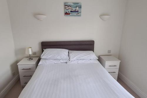 A bed or beds in a room at Beautiful 2-bed Apartment on Torquay seafront