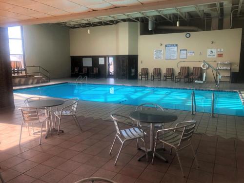 a pool with tables and chairs in front of it at Ramada by Wyndham Butte in Butte