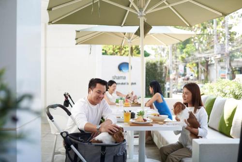 a man and woman sitting at a table with a dog at Shama Yen-Akat Bangkok in Bangkok