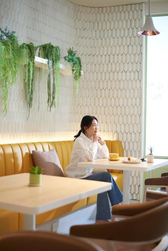 a woman sitting at a table in a restaurant at Shama Yen-Akat Bangkok in Bangkok