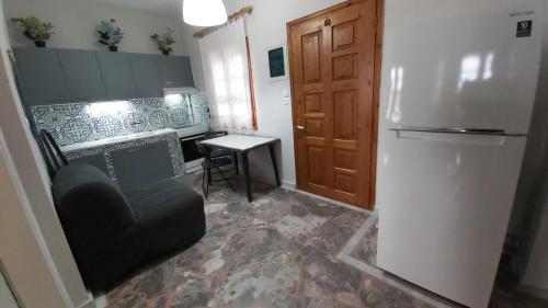 a kitchen with a refrigerator and a chair and a table at Anna's house 2 in Psakoudia