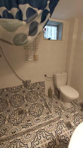a bathroom with a toilet and a floor with a pattern at Anna's house 2 in Psakoudia