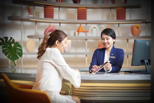 two women sitting at a counter in a store at Shama Yen-Akat Bangkok in Bangkok
