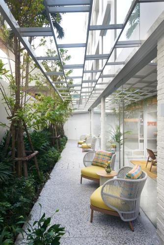 a greenhouse with chairs and tables and plants at Shama Yen-Akat Bangkok in Bangkok