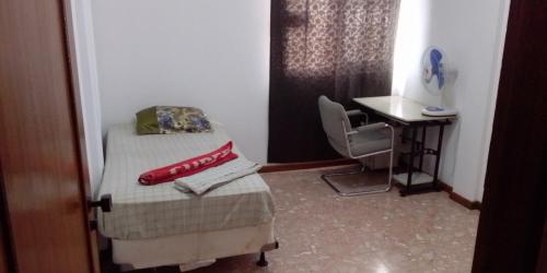 a small bedroom with a bed and a desk at Cubico Tota in Praia