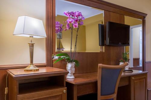 a room with a desk with a lamp and a mirror at Hotel San Michele in Milazzo