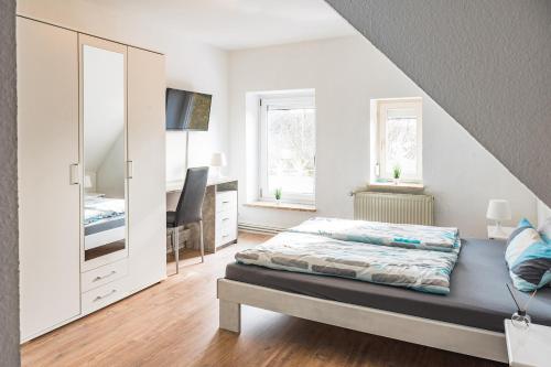 シュネーヴァーディンゲンにあるLilie Inn Pension - 24 Stunden Check Inの白いベッドルーム(ベッド1台、鏡付)