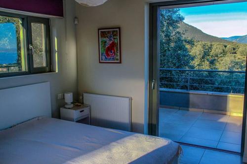a bedroom with a bed and a large window at Panoramic View Summerhouse in Loukísia
