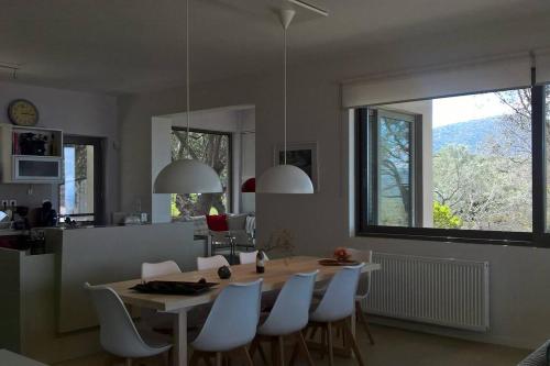 a kitchen and dining room with a table and chairs at Panoramic View Summerhouse in Loukísia