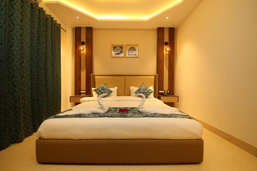 a bedroom with a large bed with white sheets at Hotel Dream Inn in Rishīkesh