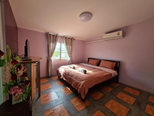 1 dormitorio con 1 cama en una habitación rosa en Kao Ngu Boutique Resort, en Ban Rong Chang