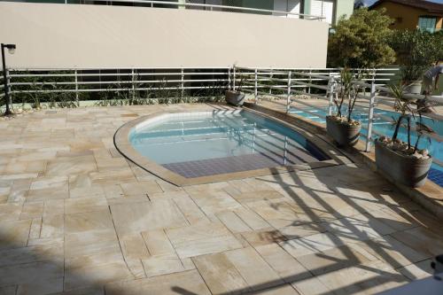 a swimming pool in the middle of a patio at Doce Lar de Bertioga frente ao Mar in Bertioga