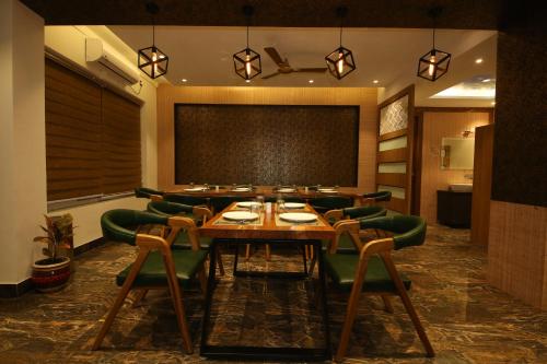 a conference room with a long table and green chairs at Hotel Dream Inn in Rishīkesh