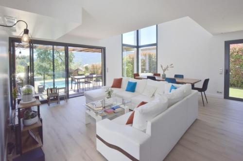 sala de estar con sofá blanco y mesa en Contemporary Villa Swimming Pool & Jacuzzi, en La Roquette-sur-Siagne