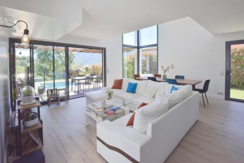 un salon avec un canapé blanc et une table dans l'établissement Contemporary Villa with Pool & Jacuzzi, à La Roquette-sur-Siagne