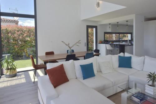 un salon avec un canapé blanc et une table dans l'établissement Contemporary Villa with Pool & Jacuzzi, à La Roquette-sur-Siagne
