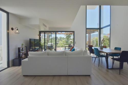 un salon avec un canapé blanc et une table dans l'établissement Contemporary Villa with Pool & Jacuzzi, à La Roquette-sur-Siagne