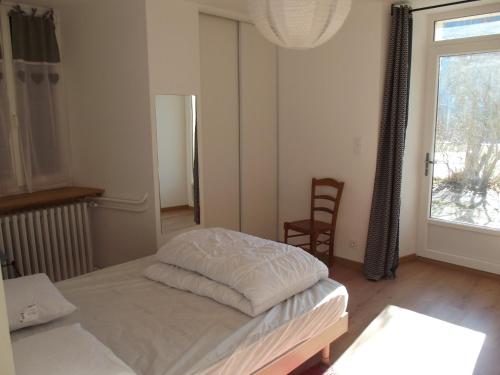 a bedroom with a bed and a window and a chair at Le Playon, classification 3 étoiles in Lus-la-Croix-Haute