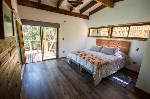 a bedroom with a bed and a large window at cabaña con tinaja en viña narbona wines in Quillota
