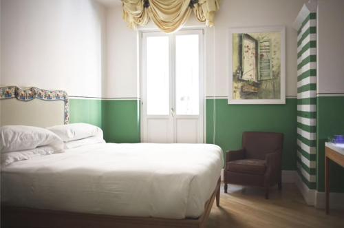 1 dormitorio con 1 cama, 1 silla y 1 ventana en Piazza di Spagna Prestige Petit, en Roma