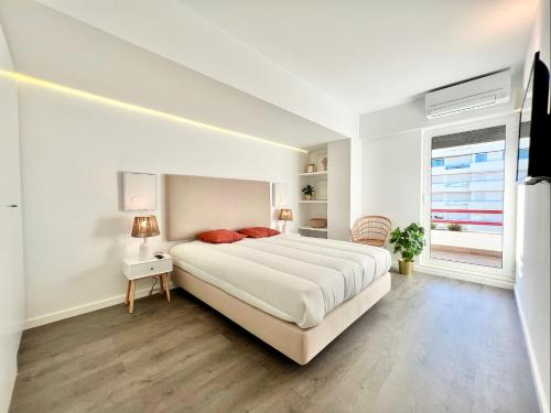 a white bedroom with a large bed and a window at Home Out Vilamoura 20 Levante in Vilamoura