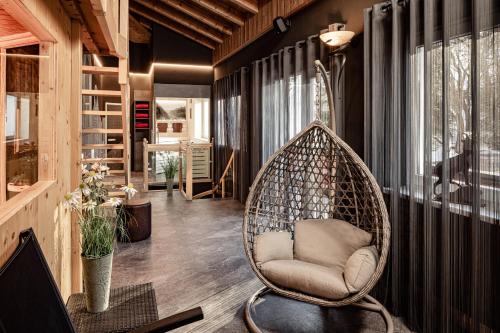a room with a rattan chair in a house at Boutique & Fashion Hotel Maciaconi - Gardenahotels in Santa Cristina in Val Gardena