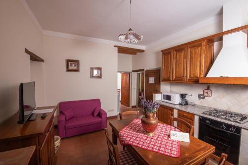 a kitchen with a table and a purple chair at Antico Fio in Poppi