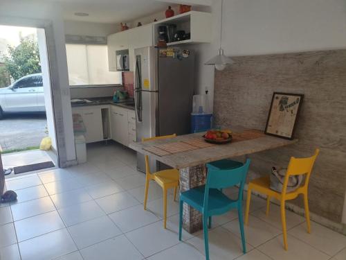 une cuisine avec une table, quatre chaises et un comptoir dans l'établissement Casa De Búzios, à Búzios