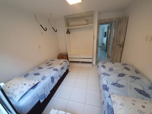 1 dormitorio con 2 camas y puerta al baño en Casa De Búzios, en Búzios