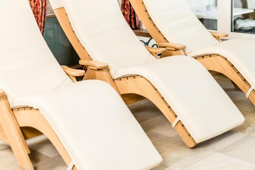 a row of white chairs lined up in a row at Romantik & Family Hotel Gardenia***S in Selva di Val Gardena