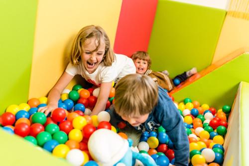 two children playing in a pile of balls at Romantik & Family Hotel Gardenia***S in Selva di Val Gardena
