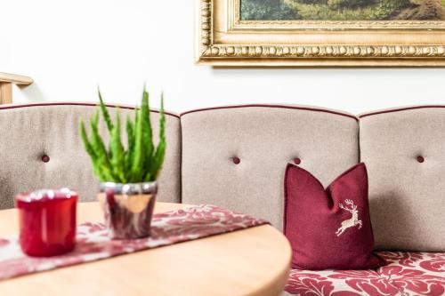 a table with purple pillows on a couch with a table sidx sidx at Romantik & Family Hotel Gardenia***S in Selva di Val Gardena