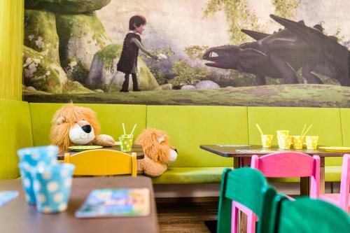 two teddy bears sitting on a couch in a restaurant at Romantik & Family Hotel Gardenia***S in Selva di Val Gardena