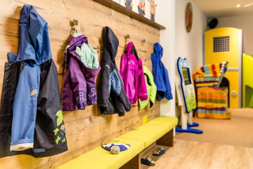 a row of jackets hanging on a wall at Romantik & Family Hotel Gardenia***S in Selva di Val Gardena