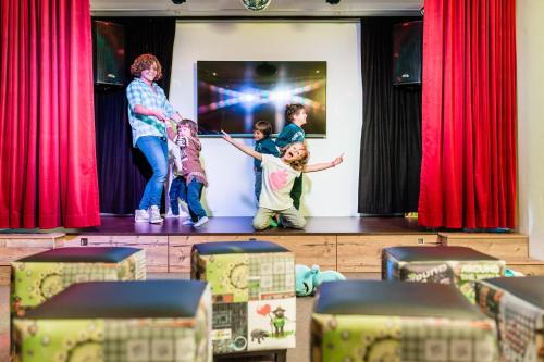 un gruppo di bambini che si trovano su un palco di Romantik & Family Hotel Gardenia***S a Selva di Val Gardena