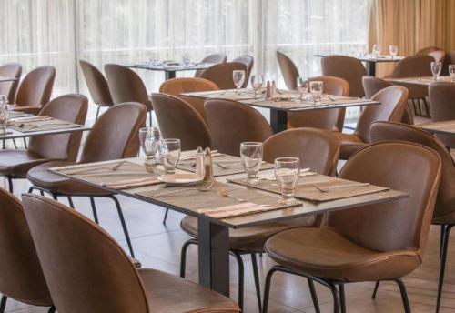 a room with tables and chairs with glasses on them at Hotel Lake House Kinneret in Tiberias